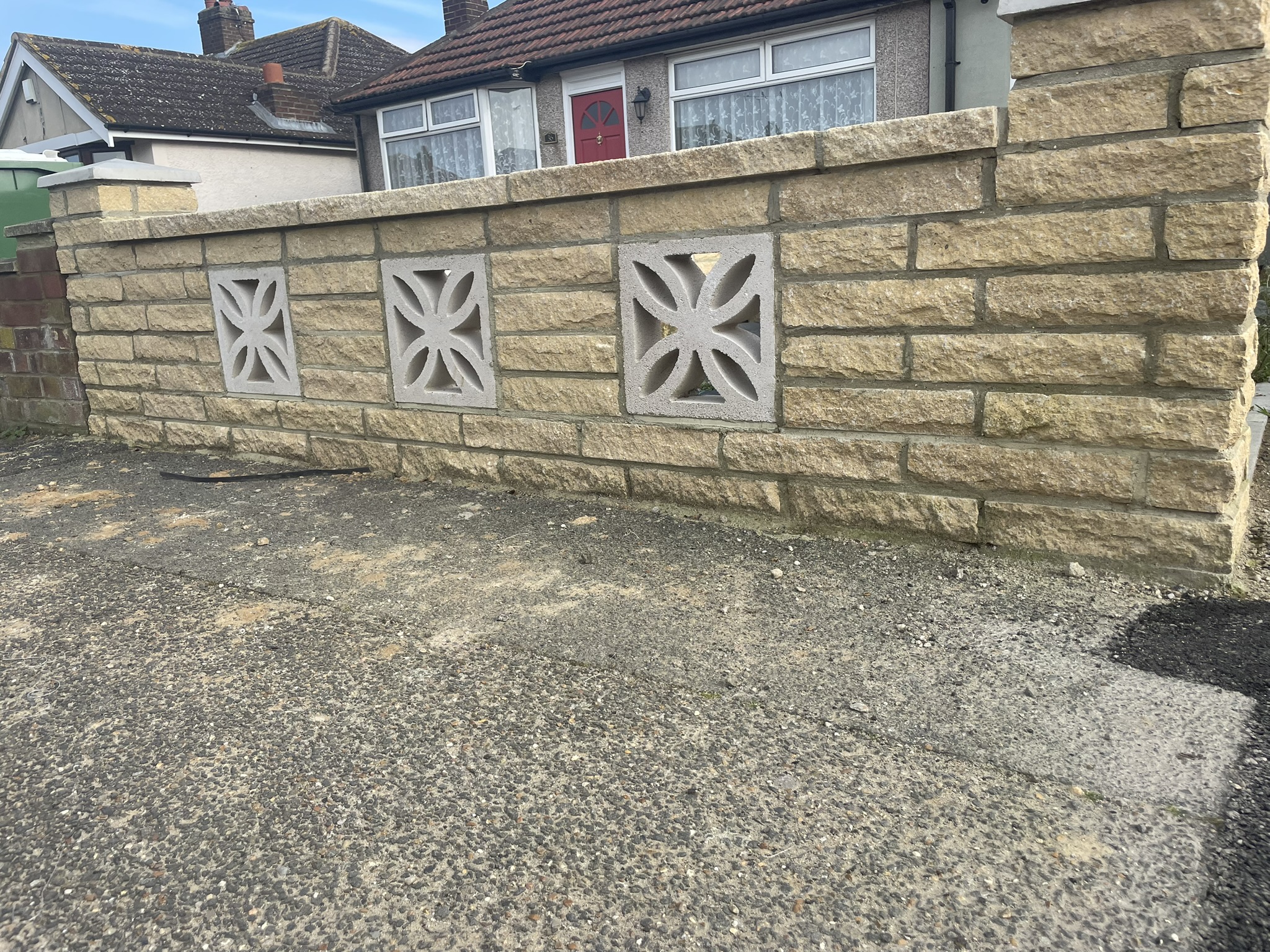 Completed garden boundary wall rebuild using reconstituted stone blocks with decorative inset panels by KDB Home Solutions