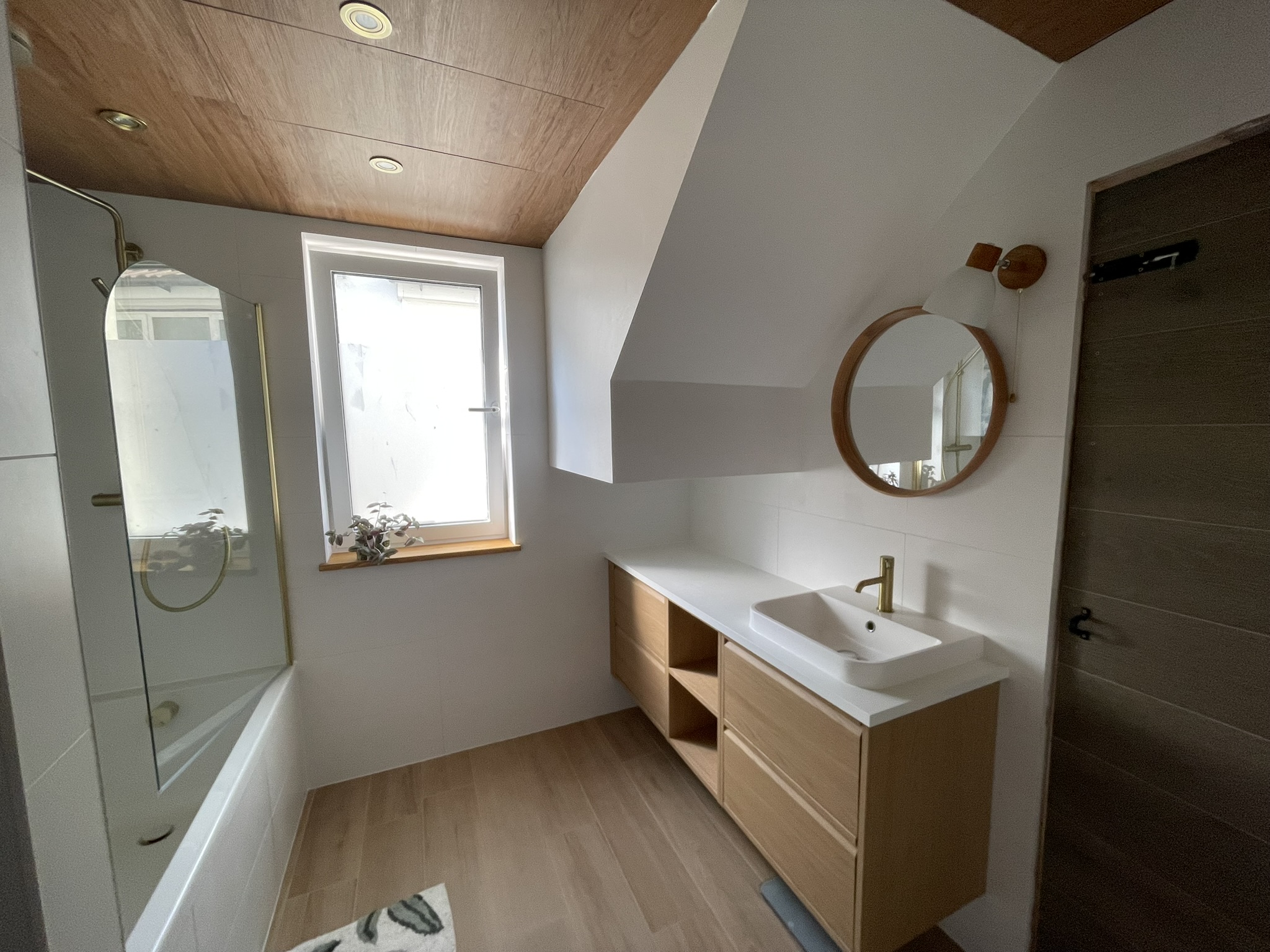 Loft bathroom with oak vanity, freestanding bath and gold shower screen by KDB Home Solutions