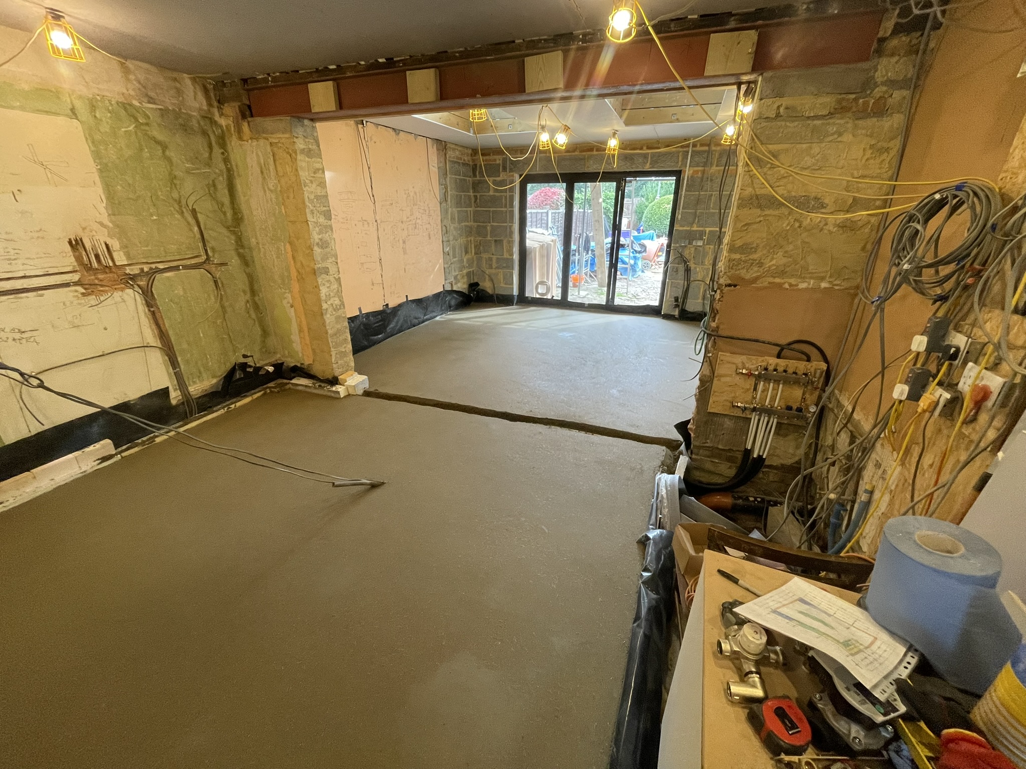 Rear extension during construction showing fresh concrete screed floor and electrical first fix by KDB Home Solutions