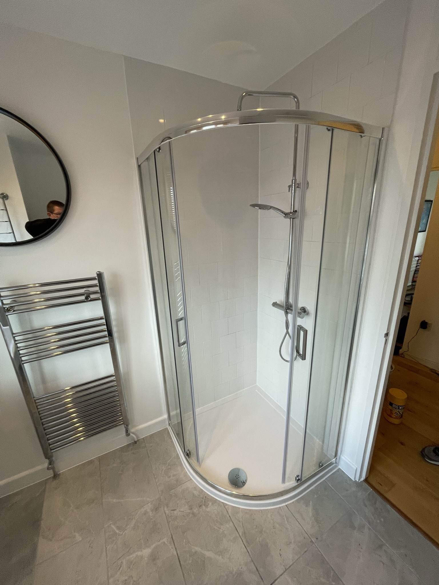 Shower room with curved quadrant enclosure and chrome heated towel rail