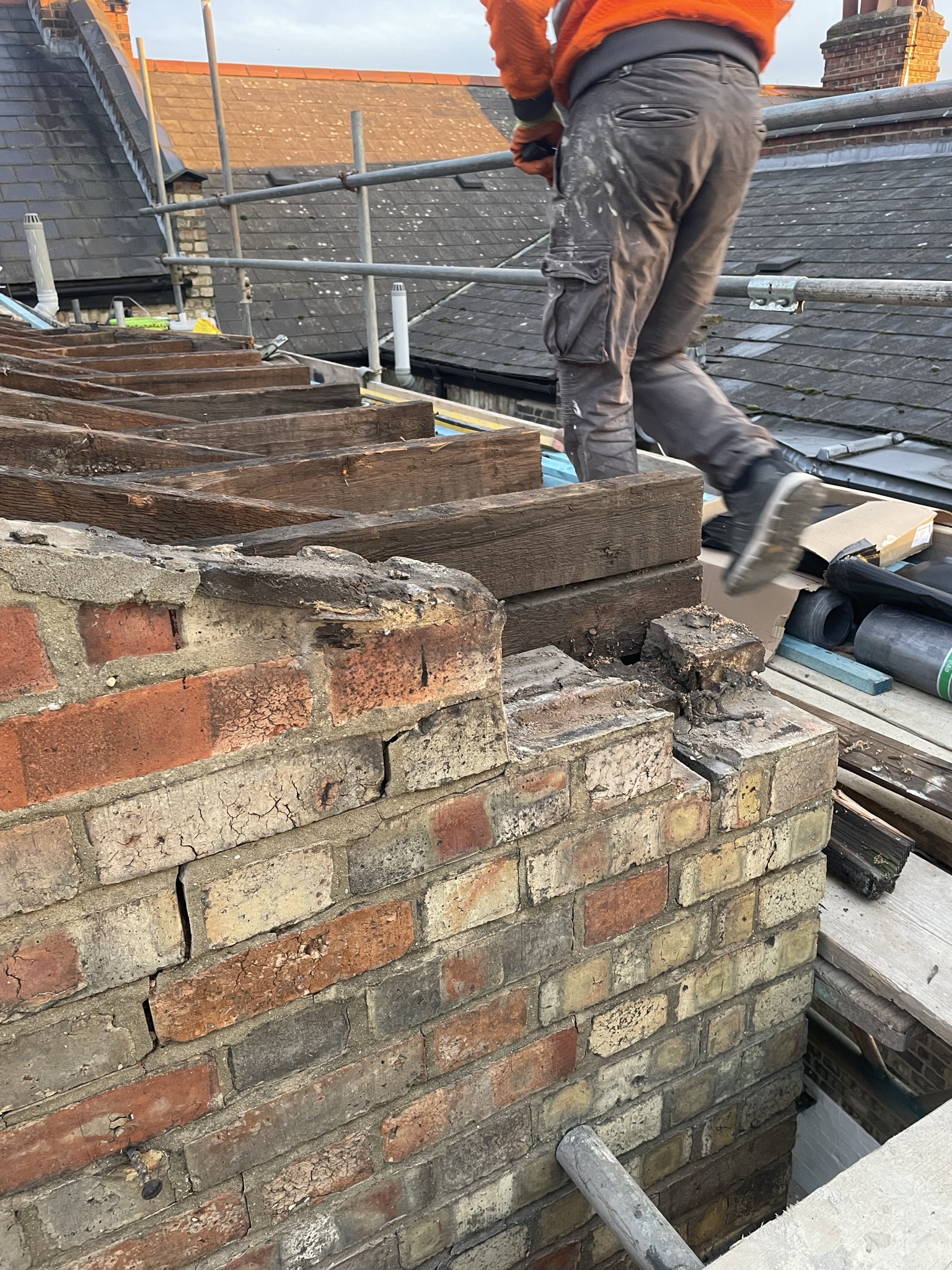 Chimney rebuild in progress with scaffolding and brickwork repairs by KDB Home Solutions